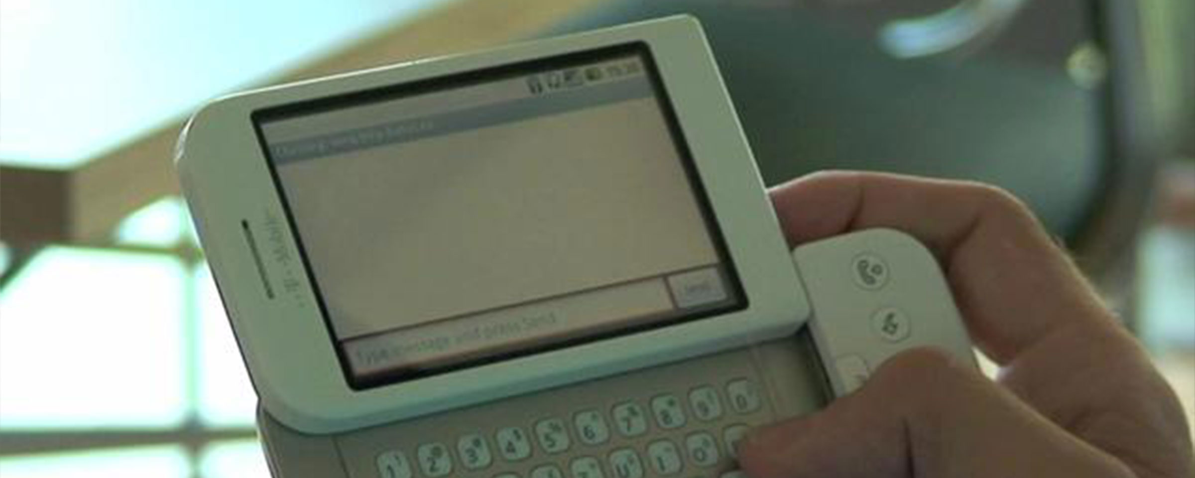 Aufgeklapptes Mobile Telefon in der Hand einer Person