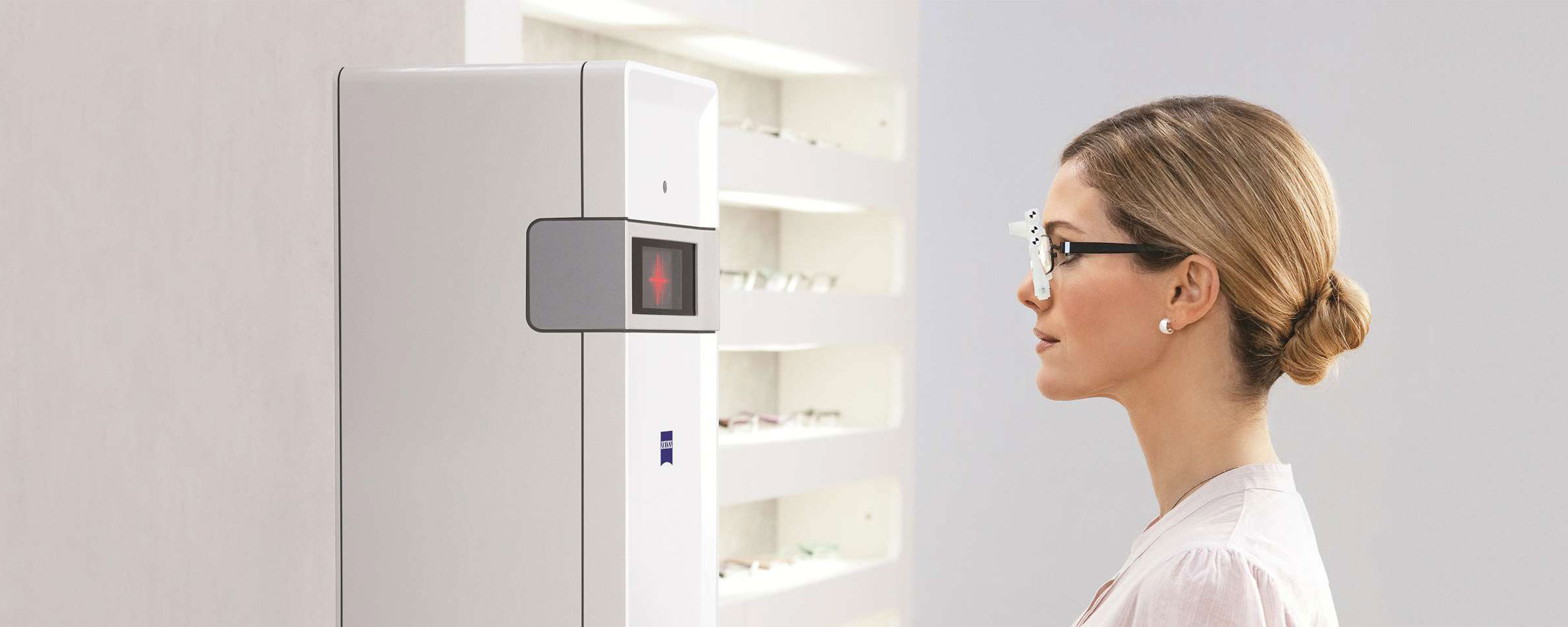 Frau, die vor einem Carl Zeiss Vision iTerminal steht, um ihre Augen ausmessen zu lassen