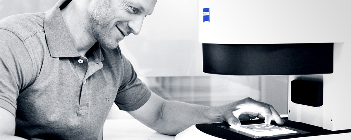 Mann legt einen Objektträger auf einen Messtisch